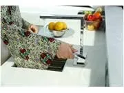 Slide: The Image of Person using a modern kitchen faucet with fruit in the background. - 27