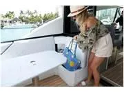 Slide: The Image of 2024 Formula 500 Super Sport Crossover interior with woman storing a bag, tropical setting. - 46