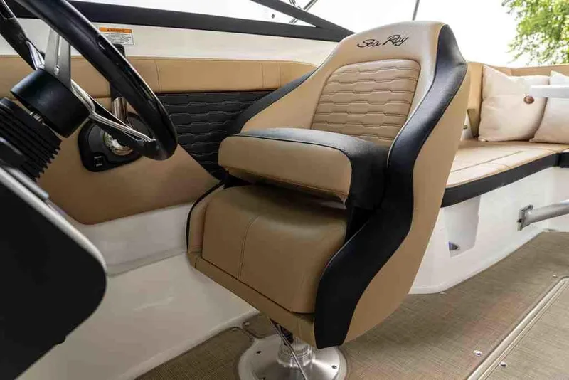 Slide: The Image of 2024 Sea Ray SPX 230 boat interior with tan and black captain's chair. - 2