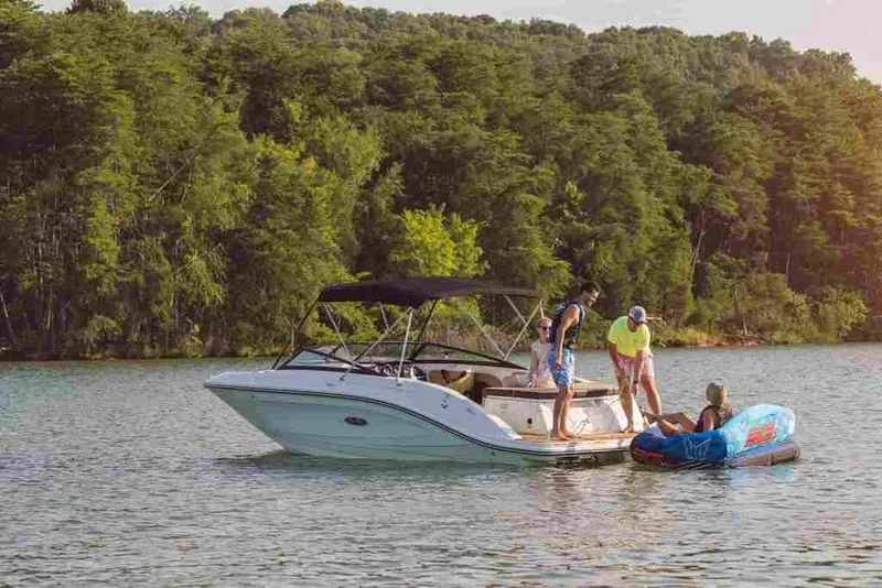 Slide: The Image of 2024 Sea Ray SPX 230 boat with people enjoying water activities on a lake. - 3