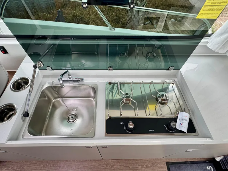 Slide: The Image of 2025 Beneteau Antares 11 kitchen with stainless steel sink and dual-burner stove. - 18