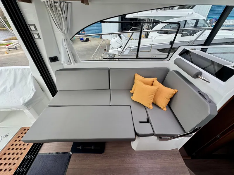 Slide: The Image of 2025 Beneteau Antares 11 interior with gray seating and yellow cushions. - 19