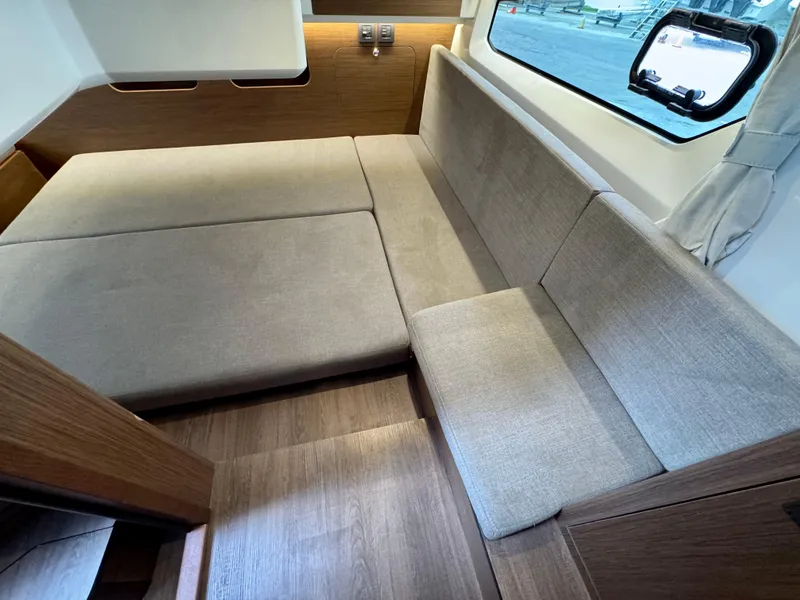 Slide: The Image of Interior of 2025 Beneteau Antares 11, featuring a cozy seating area with beige cushions. - 22