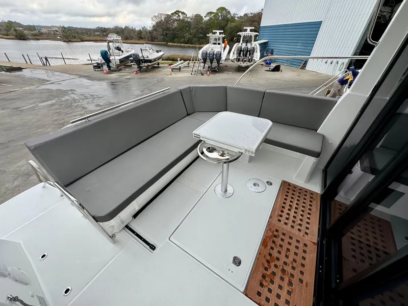 Slide: The Image of 2025 Beneteau Antares 11 boat with outdoor seating and table on deck. - 9