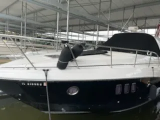 Slide: The Image of 2014 Rinker 360 Express Cruiser docked under a covered marina. - 0