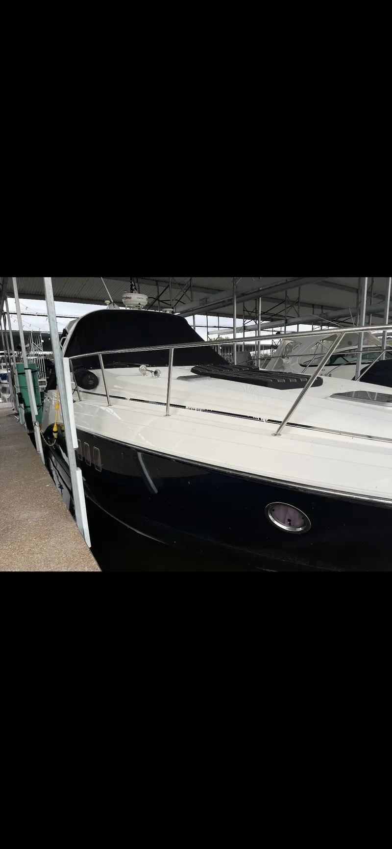 Slide: The Image of 2014 Rinker 360 Express Cruiser docked in a covered marina. - 1