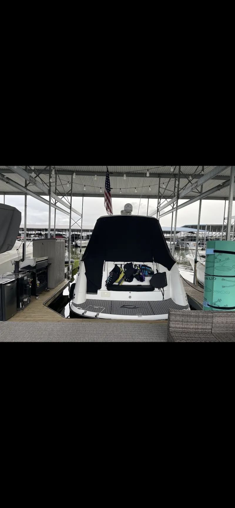 Slide: The Image of 2014 Rinker 360 Express Cruiser docked under a covered marina. - 6