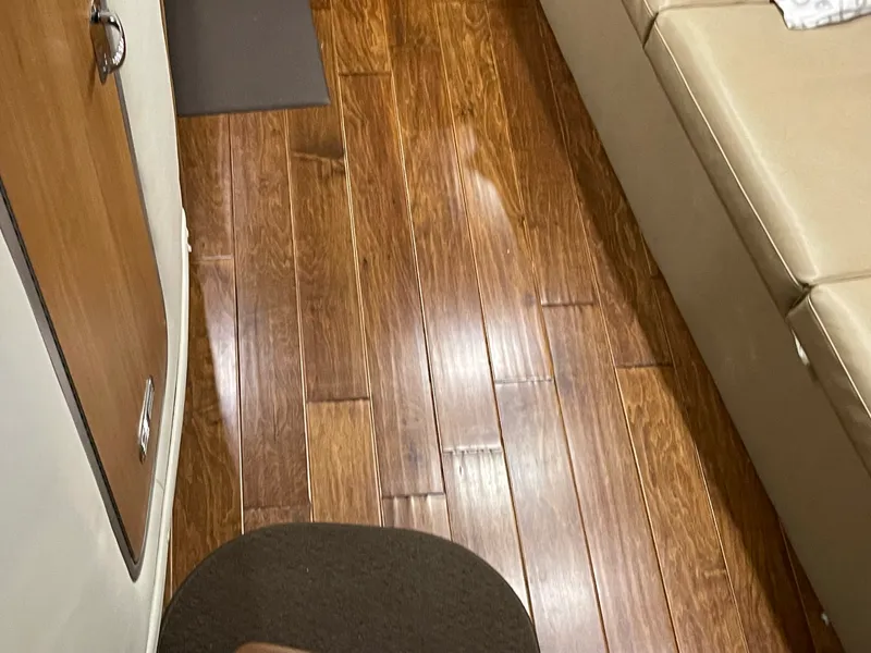 Slide: The Image of Interior of 2014 Rinker 360 Express Cruiser with wooden flooring and beige seating. - 9