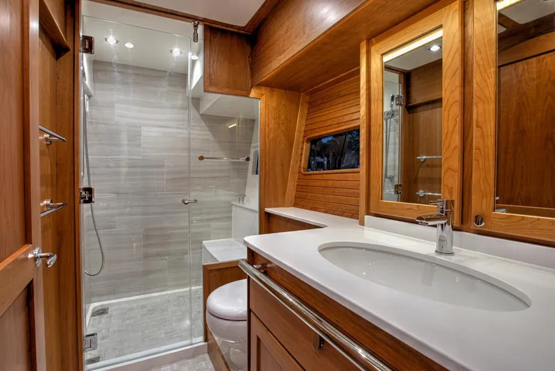 Slide: The Image of Luxurious bathroom in 2025 Sabre 58 Salon Express yacht with modern fixtures and wooden cabinetry. - 13