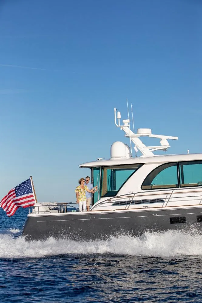 Slide: The Image of 2025 Sabre 58 Salon Express yacht cruising with American flag. - 16