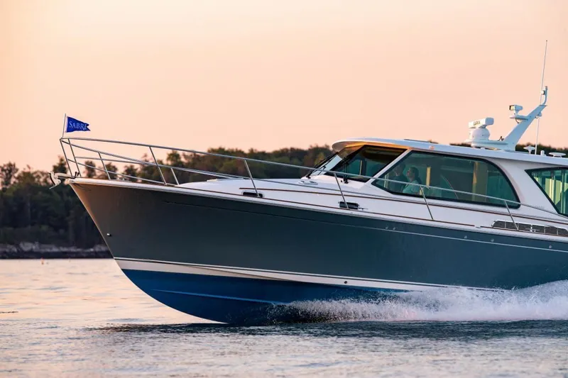 Slide: The Image of 2025 Sabre 43 Salon Express yacht cruising at sunset. - 0
