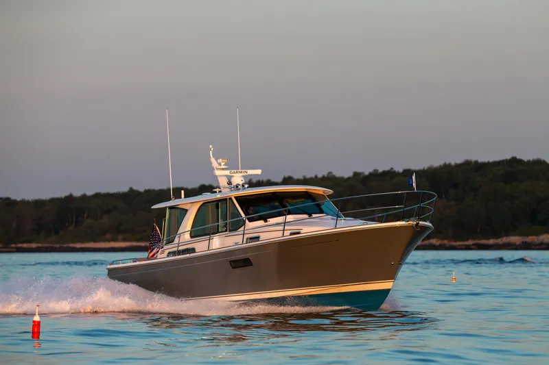 Slide: The Image of 2025 Sabre 43 Salon Express cruising on a calm lake at sunset. - 1