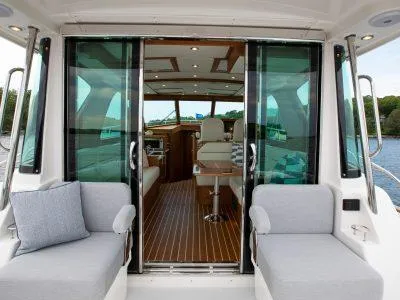 Slide: The Image of 2025 Sabre 43 Salon Express yacht interior with sliding glass doors and seating. - 4