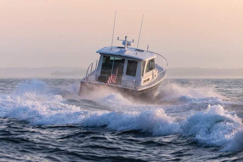 Slide: The Image of Back Cove 412 boat cruising through waves at sunrise, 2027 model. - 16