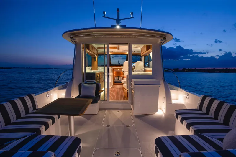 Slide: The Image of Luxurious 2027 Back Cove 412 yacht interior at sunset, featuring elegant seating and ambient lighting. - 4