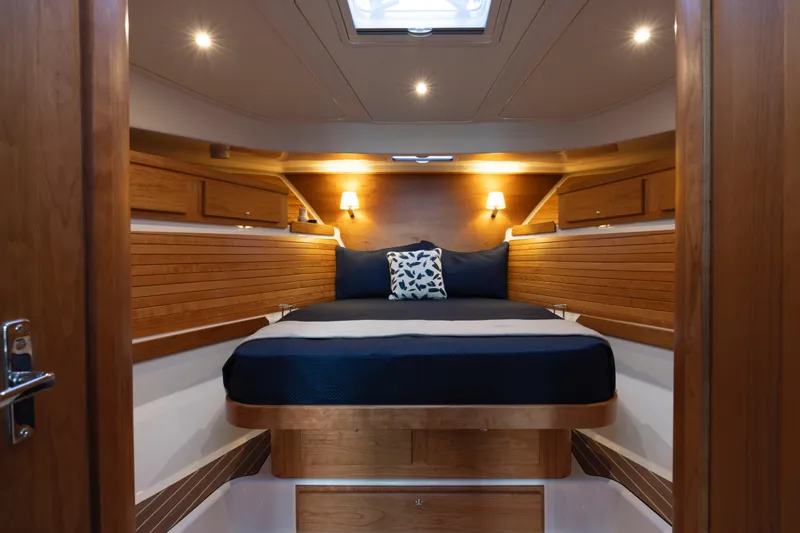 Slide: The Image of Luxurious cabin interior of 2027 Back Cove 412 yacht with cozy bed and wooden accents. - 8