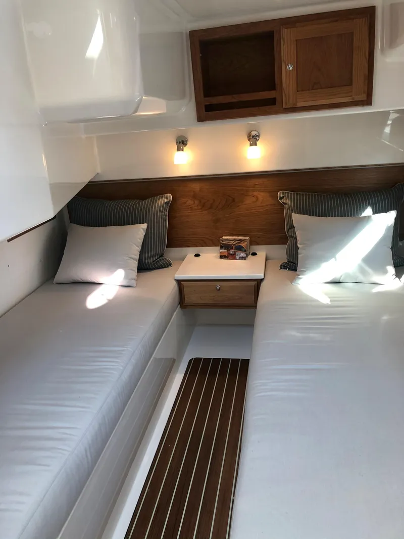 Slide: The Image of 2025 Back Cove 390 cabin interior with twin beds and wooden cabinetry. - 21