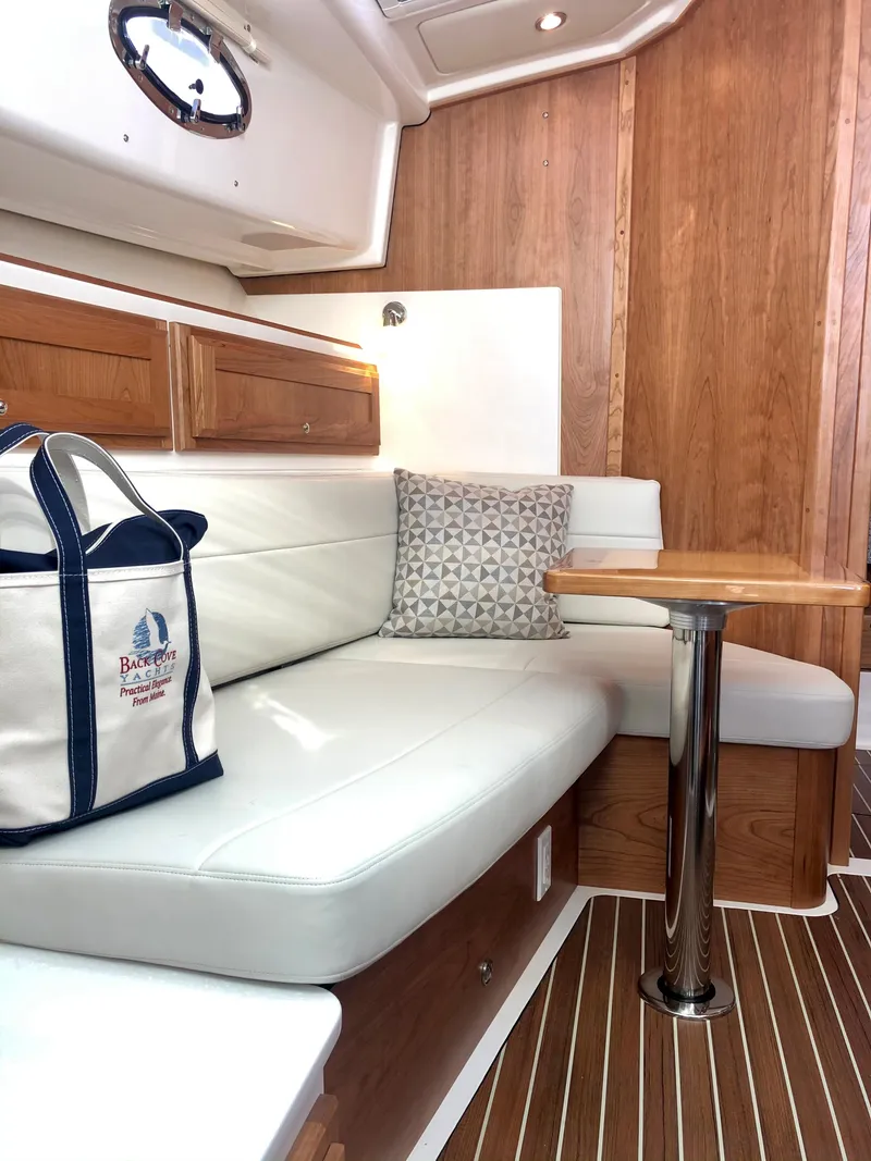 Slide: The Image of Interior of 2025 Back Cove 390 yacht with white leather seating and wooden accents. - 22