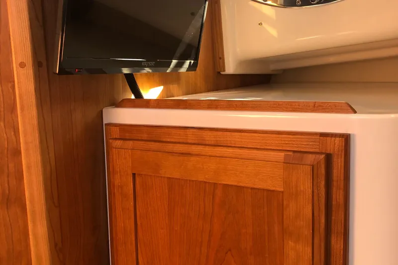 Slide: The Image of Back Cove 390 2025 interior with wooden cabinetry and mounted TV. - 23