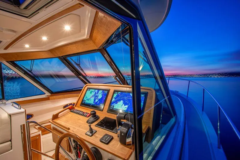 Slide: The Image of 2025 Back Cove 390 yacht cockpit with navigation screens at sunset. - 30