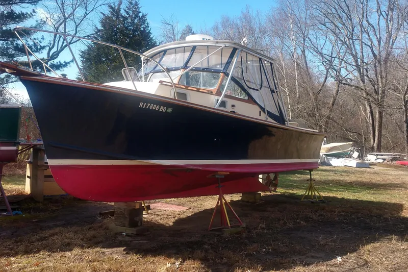 Slide: The Image of 1978 Fortier 26 boat propped up outdoors. - 13