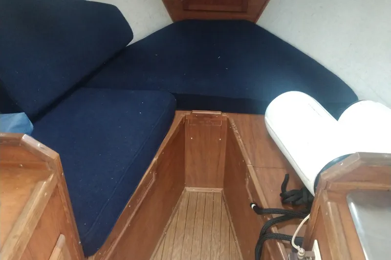 Slide: The Image of Interior of a 1978 Fortier 26 yacht with blue cushions. - 14
