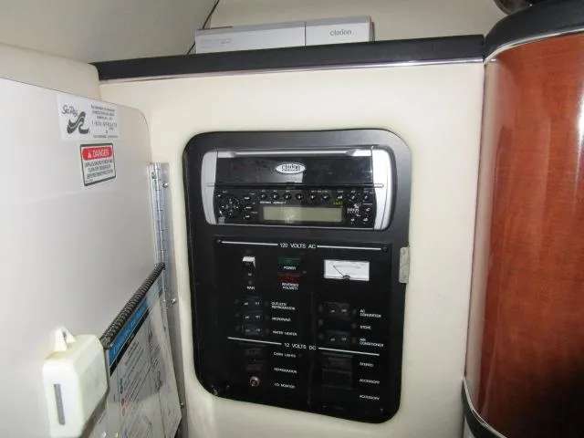 Slide: The Image of Control panel inside 2004 Sea Ray 260 Sundancer boat, featuring electrical switches and stereo system. - 12