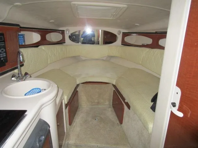 Slide: The Image of 2004 Sea Ray 260 Sundancer cabin interior with seating, sink, and storage. - 14