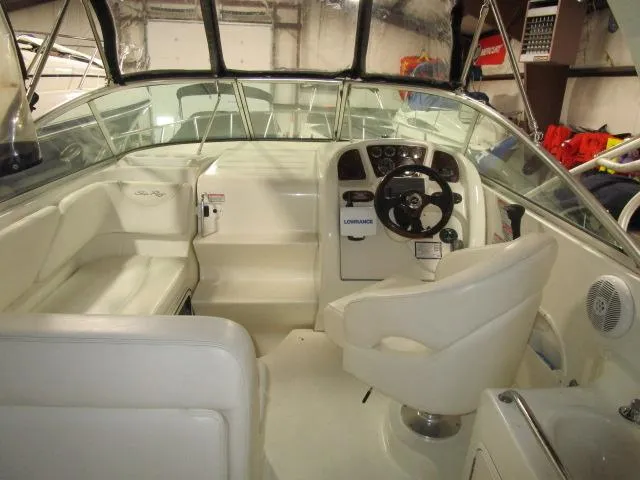 Slide: The Image of 2004 Sea Ray 260 Sundancer boat interior with steering wheel and seating area. - 4