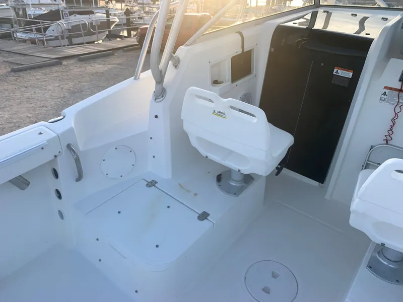 Slide: The Image of 2003 Aquasport 225 Explorer boat interior with white seating and control panel. - 18
