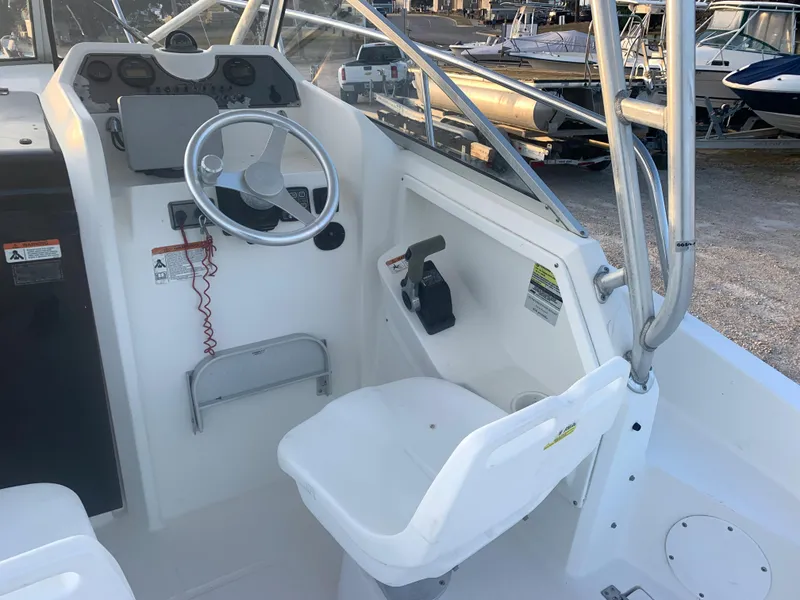 Slide: The Image of 2003 Aquasport 225 Explorer boat cockpit with steering wheel and captain's chair. - 19
