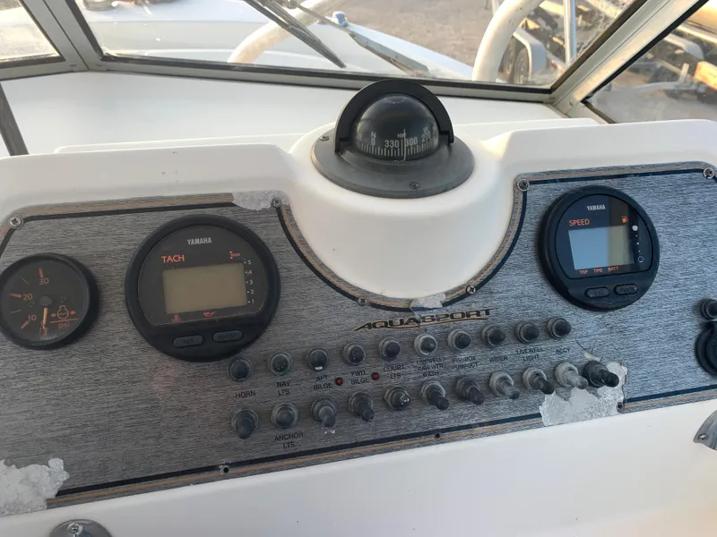 Slide: The Image of Control panel of a 2003 Aquasport 225 Explorer boat with gauges and compass. - 21