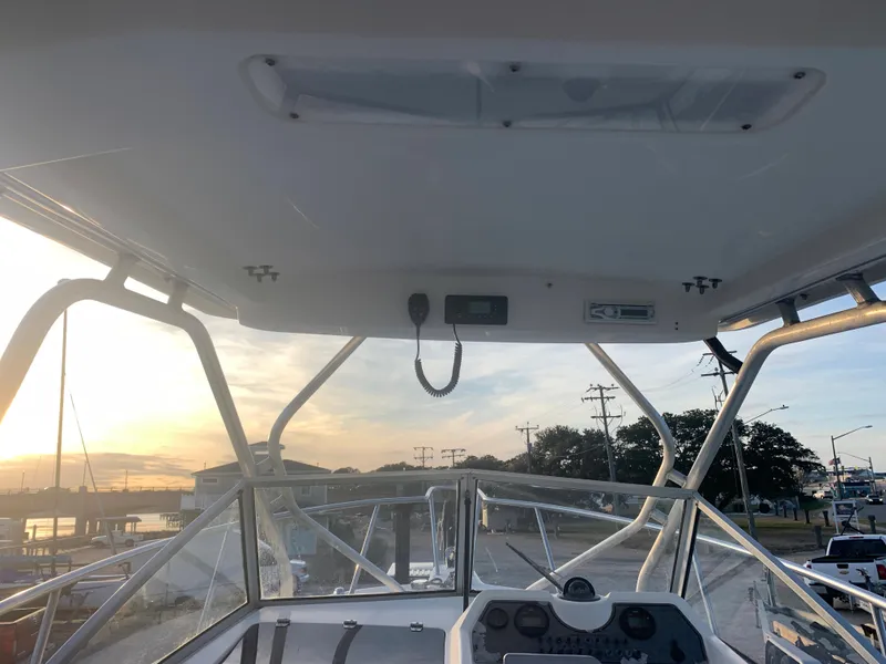 Slide: The Image of 2003 Aquasport 225 Explorer boat helm at sunset, docked at marina. - 27
