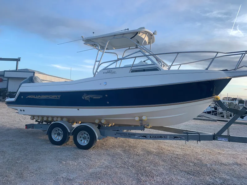 Slide: The Image of 2003 Aquasport 225 Explorer boat on trailer, side view, outdoors. - 8
