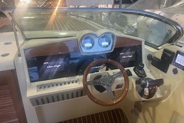 Slide: The Image of 2021 Chris-Craft Corsair 34 dashboard with wooden steering wheel and modern controls. - 15