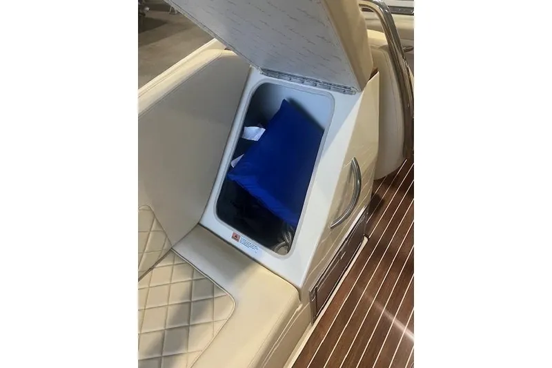 Slide: The Image of 2021 Chris-Craft Corsair 34 interior storage compartment with blue cushion and elegant seating. - 23