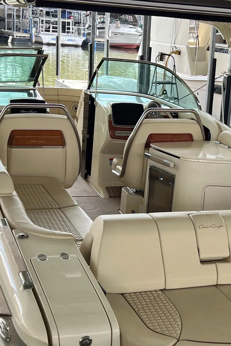Slide: The Image of 2020 Chris-Craft Launch 31 GT luxury boat interior with beige seating and wooden accents. - 12