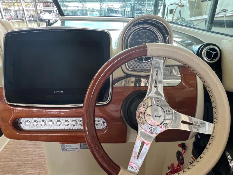 Slide: The Image of 2020 Chris-Craft Launch 31 GT dashboard with Garmin display and wood-trimmed steering wheel. - 21