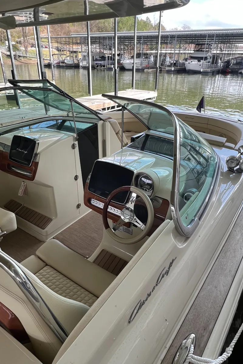 Slide: The Image of 2020 Chris-Craft Launch 31 GT boat interior with steering wheel and dashboard, docked at marina. - 34
