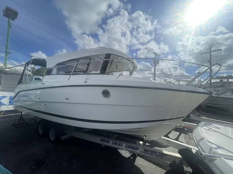 Slide: The Image of Parker 800 Weekend 2021 boat interior with seating and table, docked under a blue sky. - 16