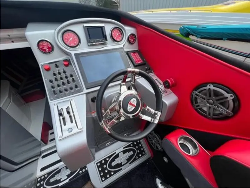 Slide: The Image of Interior cockpit of a 2016 Cigarette 50' Marauder boat with advanced controls and red accents. - 10
