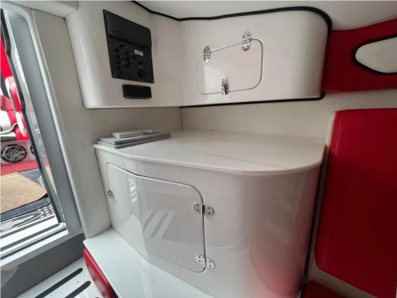 Slide: The Image of Interior of a 2016 Cigarette 50' Marauder boat, featuring sleek white cabinetry and red accents. - 17