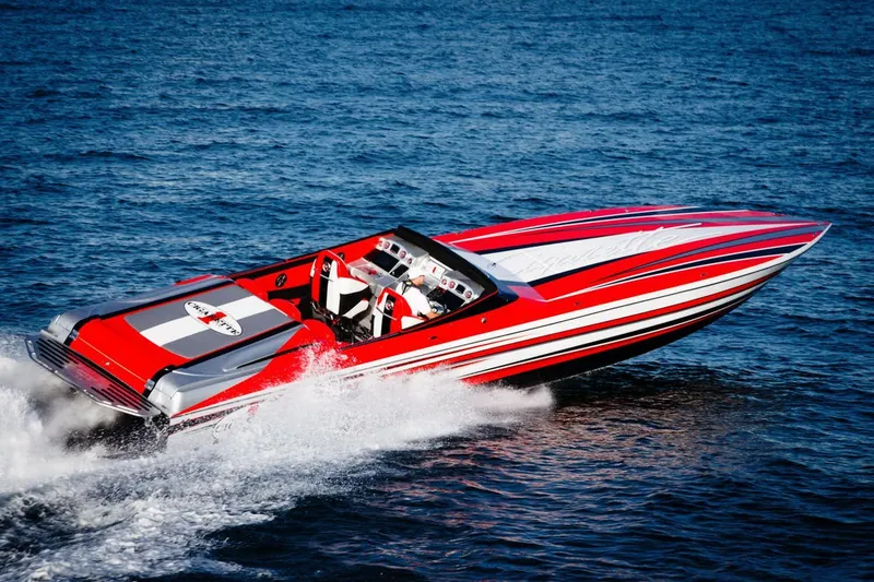 Slide: The Image of 2016 Cigarette 50' Marauder speedboat cruising on open water, featuring sleek red and white design. - 2