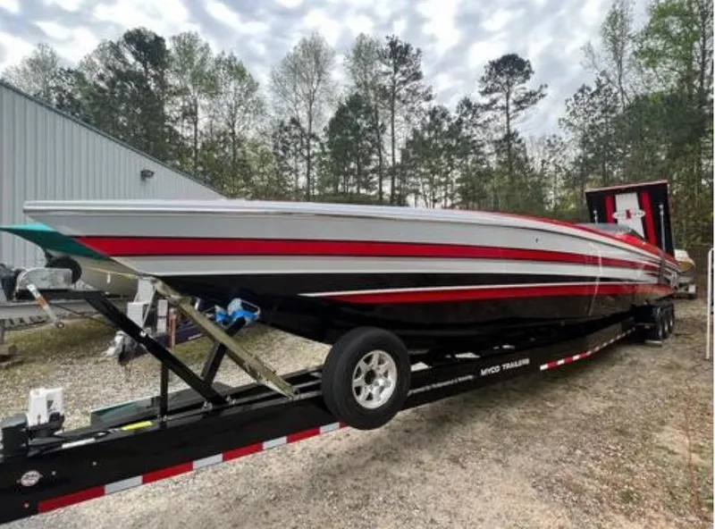 Slide: The Image of 2016 Cigarette 50' Marauder speedboat on trailer, featuring sleek red and black design. - 32
