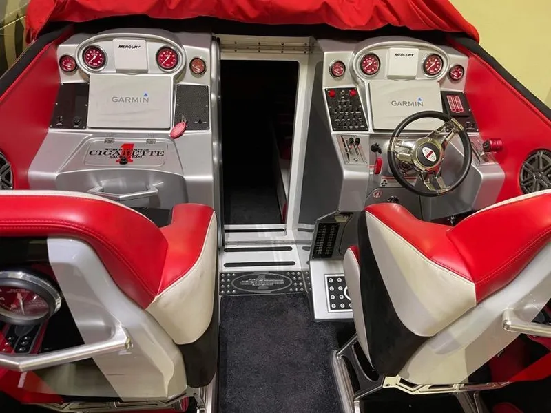 Slide: The Image of 2016 Cigarette 50' Marauder boat interior with red and white seats, Garmin displays, and Mercury controls. - 9