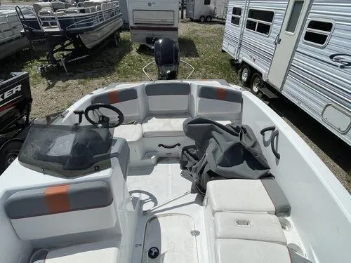 Slide: The Image of 2019 Tahoe T16 boat interior with seating and steering wheel, parked near RVs. - 10
