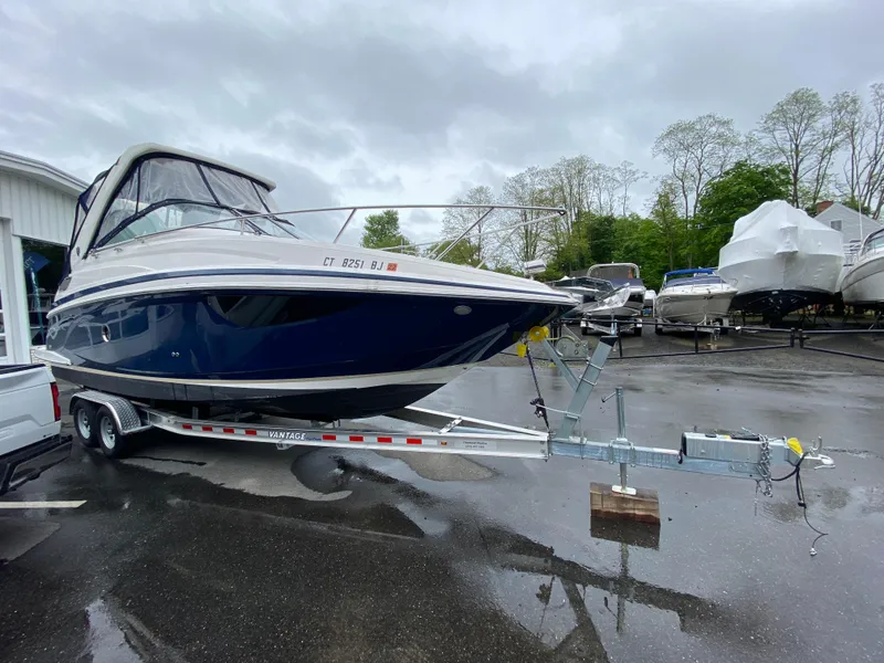 Slide: The Image of 2018 Regal 28 Express boat on a trailer in a marina parking lot. - 17
