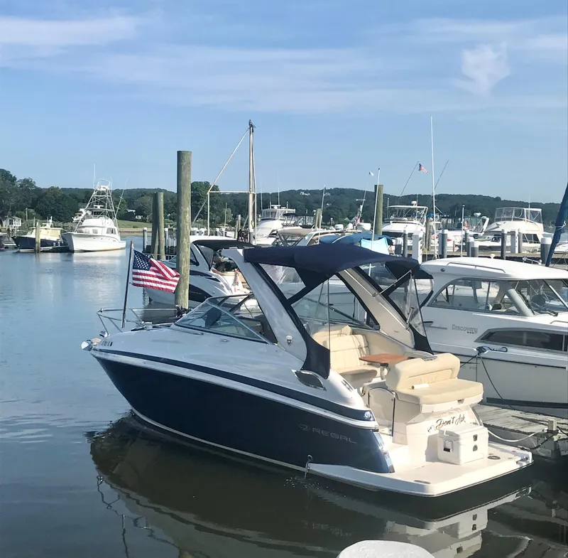 Slide: The Image of 2018 Regal 28 Express boat docked at a marina with other boats. - 4