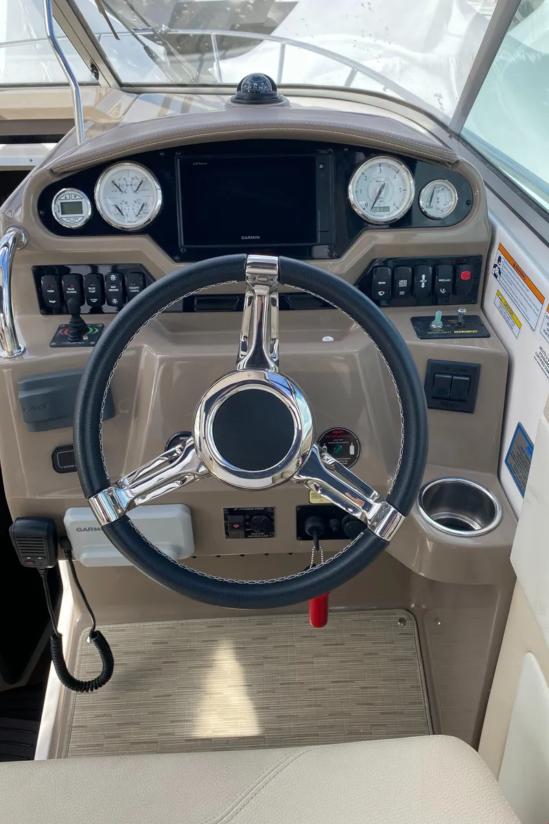 Slide: The Image of 2018 Regal 28 Express boat helm with steering wheel and control panel. - 7