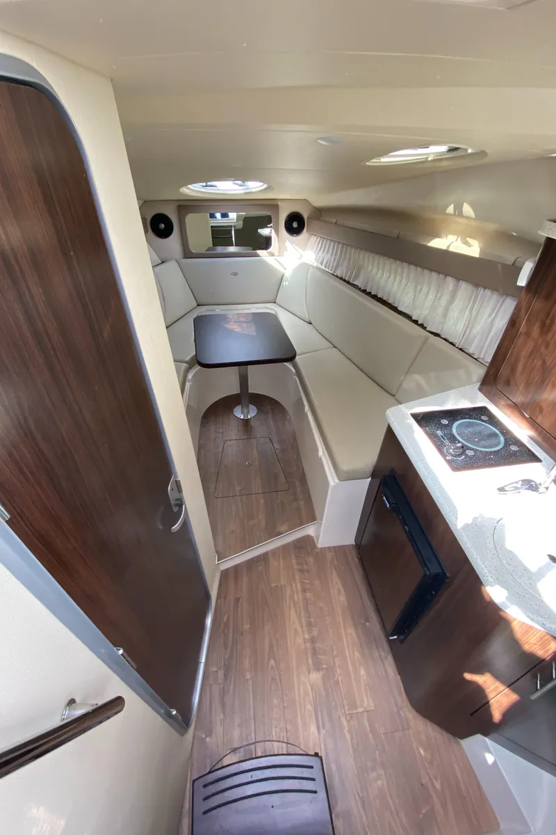 Slide: The Image of Interior of 2018 Regal 28 Express boat with seating, table, and kitchenette. - 9